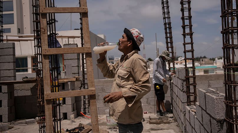 Jorge Moreno, a worker, drinks flavoured water to cope with the heatwave during his workday at a construction site in Veracruz, Mexico, on 17 June 2024. 