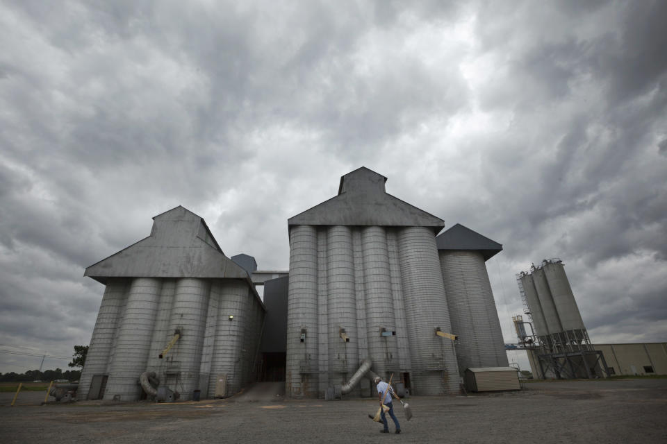 Storm clouds leading remnants of Hurricane Isaac gather in the skies over a grain elevator in England, Ark., as a man carries tools into a gust of wind Thursday, Aug. 30, 2012. With the storms approaching many farm states, some farmers wonder whether too much relief is on the horizon. (AP Photo/Danny Johnston)