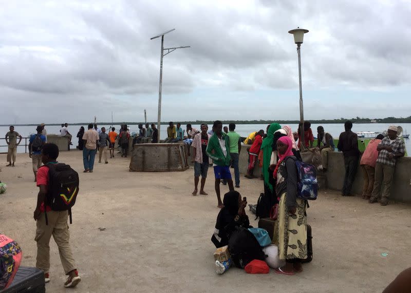 Travellers are seen gathered at the Lamu jetty following an attack by Somalia's Islamist group al Shabaab on a military base in Manda, Lamu