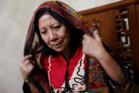 Nina Widyawati, 65-year-old mother, wears a scarf given by her daughter Ratih Purwarini, a doctor who passed away due to the coronavirus disease (COVID-19), at her house in Jakarta