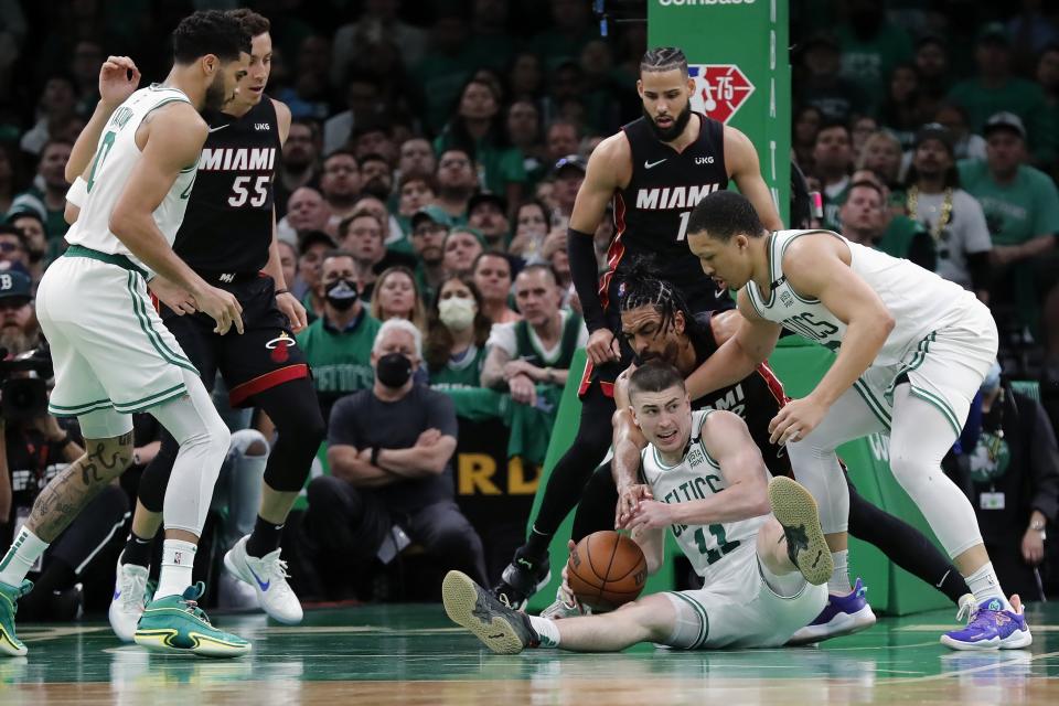 Boston Celtics' Payton Pritchard (11) and Grant Williams, right, vie for possession of the ball against Miami Heat's Gabe Vincent during the first half of Game 3 of the NBA basketball playoffs Eastern Conference finals Saturday, May 21, 2022, in Boston. (AP Photo/Michael Dwyer)