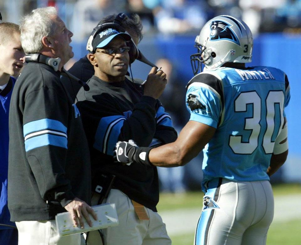 Carolina Panthers linebackers coach Sam Mills, center, talks with Mike Minter, right, and head coach John Fox, left, during a timeout in their 21-14 win over Tampa Bay in Charlotte, N.C., Nov. 28, 2004.