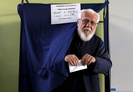 A Greek Orthodox priest exits a booth holding a ballot at a polling station in Athens, Greece July 5, 2015. REUTERS/Yannis Behrakis