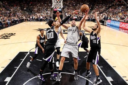 Mar 5, 2016; San Antonio, TX, USA; San Antonio Spurs shooting guard Manu Ginobili (20) shoots the ball as Sacramento Kings center Willie Cauley-Stein (00) and small forward Omri Casspi (18) defend during the second half at AT&T Center. Mandatory Credit: Soobum Im-USA TODAY Sports