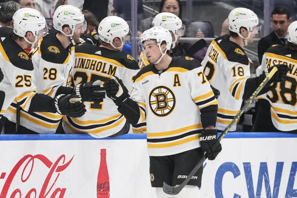 Boston Bruins' Charlie McAvoy (73) celebrates with teammates Brandon Carlo (25) and Derek Forbort (28) after scoring a goal during the second period of an NHL hockey game against the New York Islanders Wednesday, Jan. 18, 2023, in Elmont, N.Y. (AP Photo/Frank Franklin II)