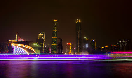 FILE PHOTO: A long exposure picture of boats passing by a business area along the Pearl River in Guangzhou, Guangdong province, March 22, 2014. REUTERS/Alex Lee/File Photo