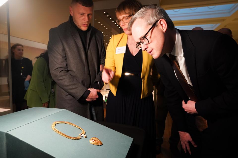 The finder of the chain and pendant associated with Henry VIII and Katherine of Aragon, Charlie Clarke (left) and Arts and Heritage Minister, Lord Parkinson of Whitley Bay (right) look at the pendant on display at the British Museum in London as archaeological discoveries made by members of the public are revealed via the Portable Antiquities Scheme (PAS). Picture date: Tuesday January 31, 2023.