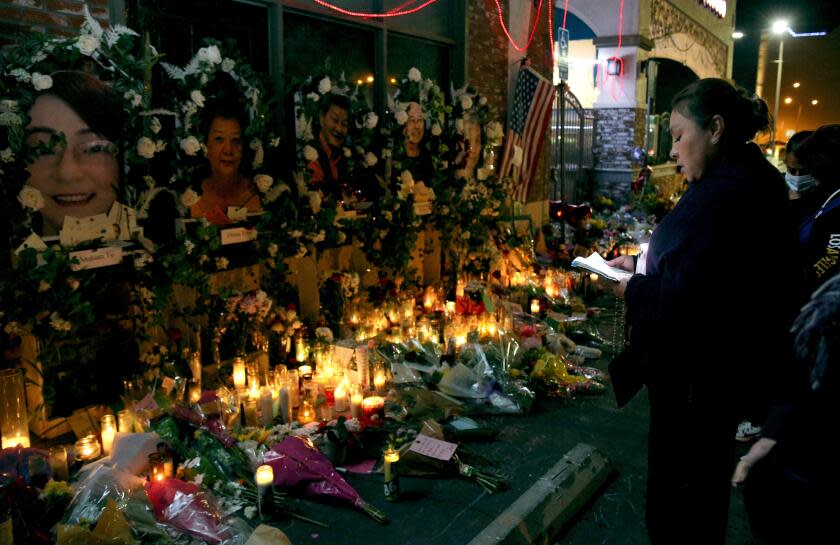 Martha Martinez, 51 of Monterey Park, recites the Rosary for the 11 shooting victims, at the memorial site in front of Star Ballroom Dance Studio in Monterey Park on Thursday, Jan. 26, 2023. Martinez has been coming daily to the memorial recite the Rosary.