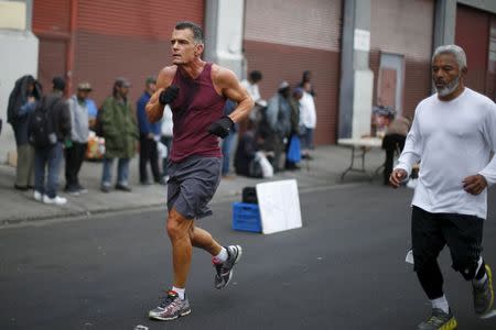Los Angeles Superior Court Judge Craig Mitchell, 58, (L) leads Oscar Knight, 53, and other runners from the Midnight Mission Running Club on a sunrise run through Skid Row in Los Angeles, California April 20, 2015. REUTERS/Lucy Nicholson