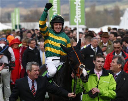 Barry Geraghty on Jezki celebrates as he enters the winners enclosure after winning the Champion Hurdle Challenge Trophy at the Cheltenham Festival horse racing meet in Gloucestershire, western England March 11, 2014. REUTERS/Eddie Keogh