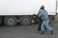 Russian police detain a migrant worker during a raid at a vegetable warehouse complex in the Biryulyovo district of Moscow October 14, 2013. REUTERS/Ivan Stolpnikov