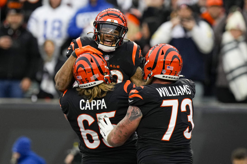 Cincinnati Bengals running back Joe Mixon, top, celebrates a touchdown with Alex Cappa (65) and Jonah Williams (73) in the first half of an NFL football game against the Indianapolis Colts in Cincinnati, Sunday, Dec. 10, 2023. (AP Photo/Carolyn Kaster)
