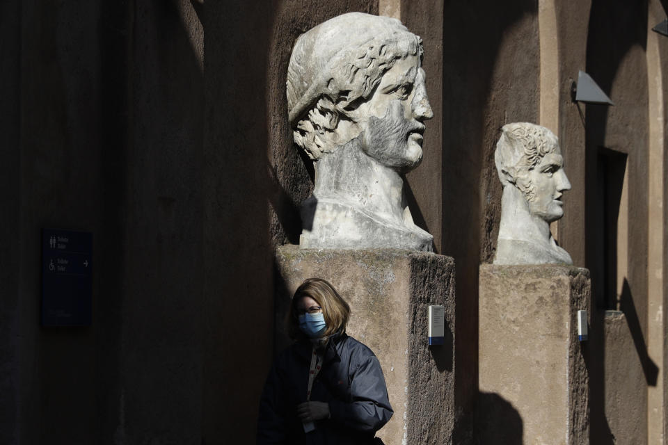 A museum usher stands by marble busts at the entrance of the Sant'Angelo castle In Rome Tuesday, March 2, 2021. The first anti-pandemic decree from Italy’s new premier, Mario Draghi, tightens measures governing school attendance while easing restrictions on museums, theaters and cinemas. Italy, a nation of 60 million people where COVID-19 first erupted in the West in February 2020, has registered nearly 3 million confirmed cases. Its known death toll of more than 98,000,is the second-highest in Europe, after Britain’s. (AP Photo/Gregorio Borgia)