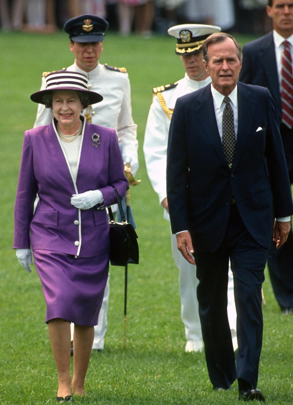 Queen Elizabeth II (left) and US President George HW Bush (1925 - 2018) walk together on the White House's South Lawn, Washington DC, May 14, 1991