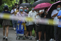 Residents wearing face masks wait in line to get their routine COVID-19 throat swabs at a coronavirus testing site in Beijing, Tuesday, Aug. 9, 2022. Chinese authorities have closed Tibet's famed Potala Palace after a minor outbreak of COVID-19 was reported in the Himalayan region. (AP Photo/Andy Wong)