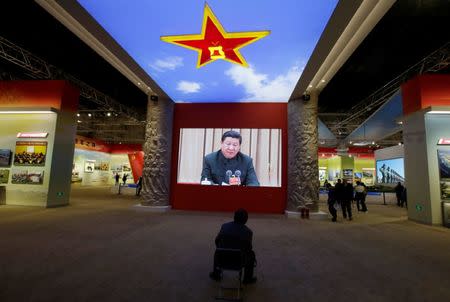 A visitor watches a video showing Chinese President Xi Jinping at a military meeting during an exhibition displaying China's achievements for the past five years, as a part of the celebrations of the upcoming 19th National Congress of the Communist Party of China (CPC) at Beijing Exhibition Centre in Beijing, China October 10, 2017. REUTERS/Jason Lee