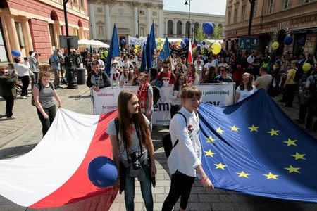 People hold European Union and Polish flags during the annual EU parade in Warsaw, Poland May 6, 2017. Agencja Gazeta/Dawid Zuchowicz via REUTERS