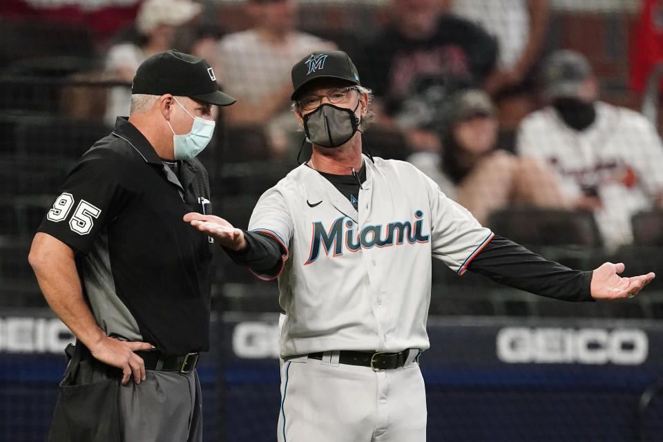 Miami Marlins manager Don Mattingly, right, argues with umpire Tim Timmons, left, after a play was video reviewed during the eighth inning of a baseball game against the Atlanta Braves Monday, April 12, 2021, in Atlanta. (AP Photo/John Bazemore)