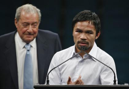 Promoter Bob Arum (L) watches as Manny Pacquiao answers reporters after his fight with Floyd Mayweather. (AP)