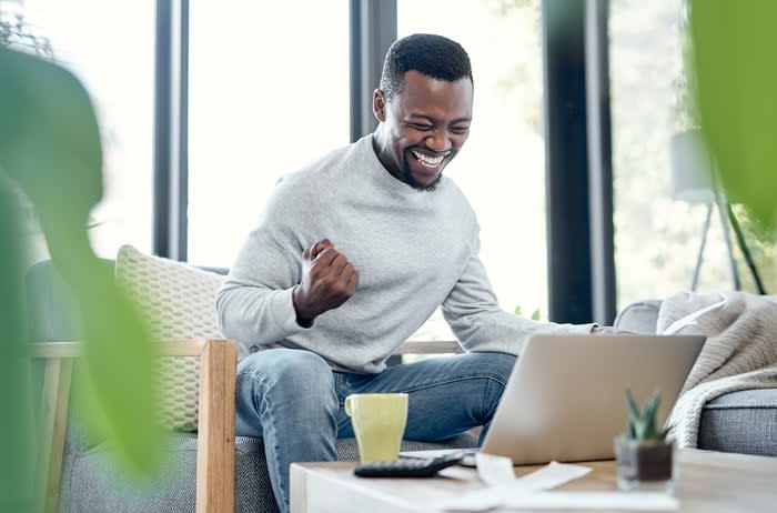 A person celebrating in front of a computer.