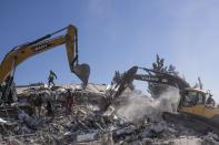 Rescuers supported by heavy machines search a destroyed building in Nurdagi, southeastern Turkey, Thursday, Feb. 9, 2023. Thousands who lost their homes in a catastrophic earthquake huddled around campfires and clamored for food and water in the bitter cold, three days after the temblor and series of aftershocks hit Turkey and Syria. (AP Photo/Petros Giannakouris)