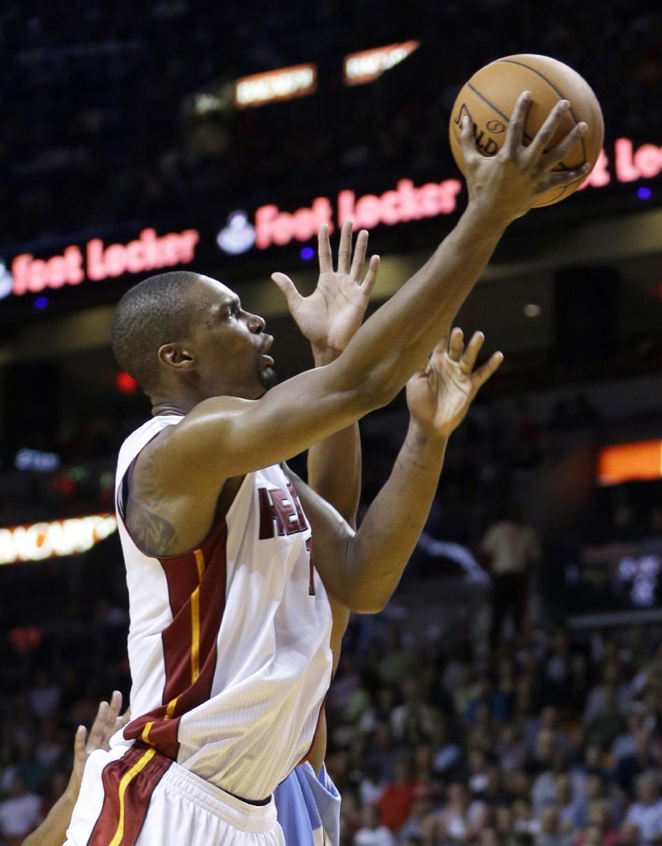 Miami Heat forward Chris Bosh (1) goes to the basket against the Denver Nuggets during the first half of an NBA basketball game in Miami, Friday, March 14, 2014. (AP Photo/Alan Diaz)