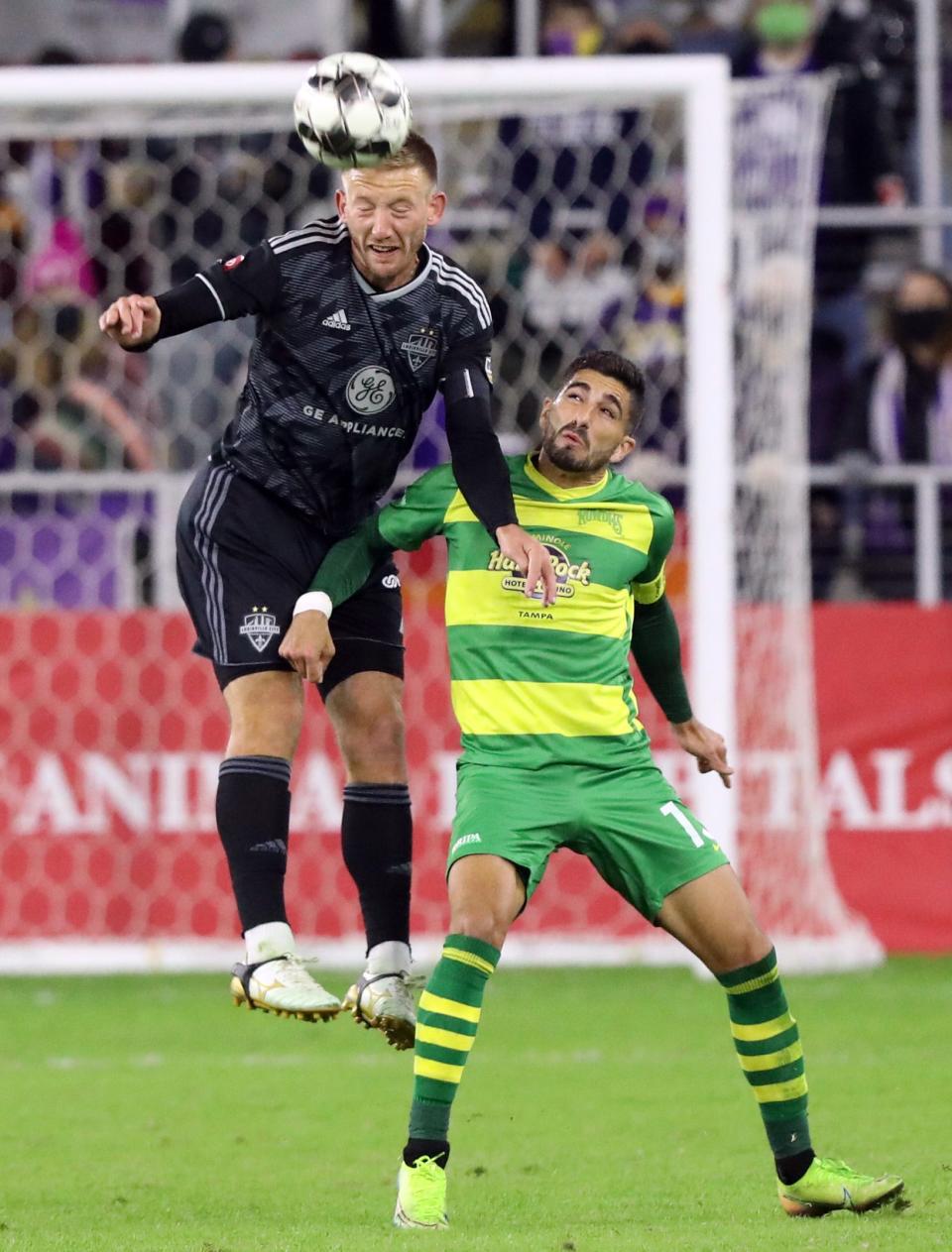 Louisville City FC's Sean Totsch (4) fights for the ball with Tampa Bay Rowdies' Sebastian Guenzatti (13) during the second half of play in the Eastern Conference Final game at Lynn Family Stadium in Louisville, Kentucky.     October 24,  2020.