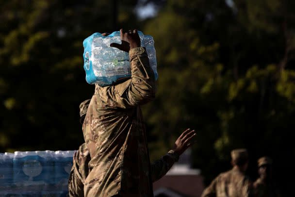 PHOTO: A member of the National Guard carries bottles of drinking water at a distribution site in Jackson, Mississippi, Sept. 1, 2022.  (Carlos Barria/Reuters)