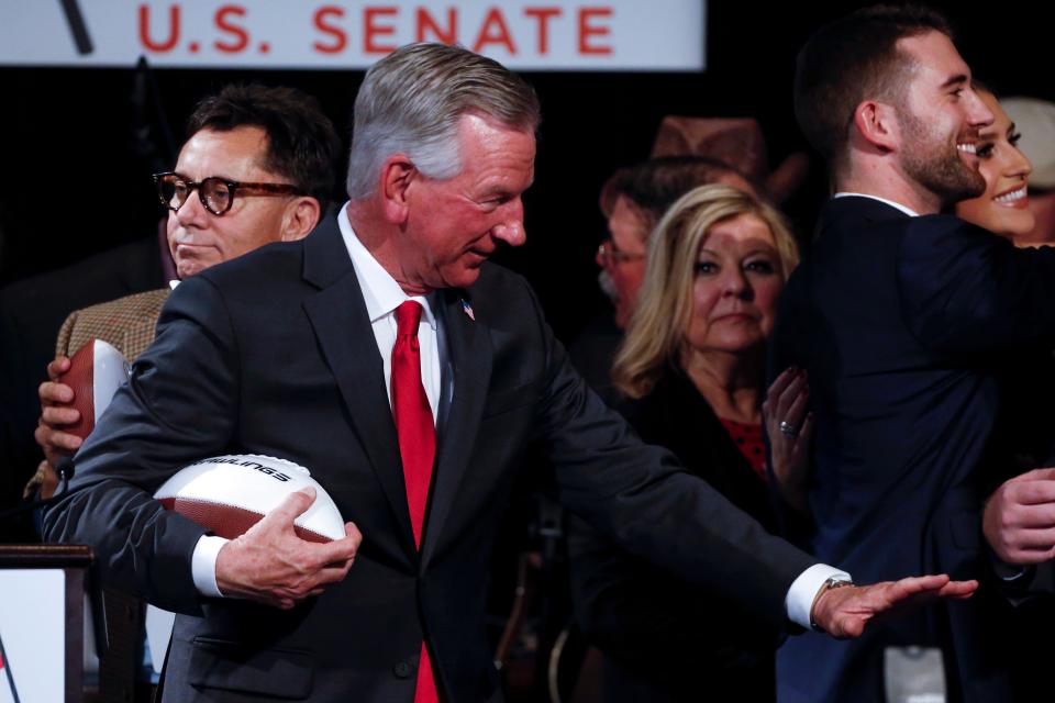 Sen.-elect Tommy Tuberville, a former college football coach, gives the Heisman Trophy pose after delivering his victory speech to supporters on Nov. 3, 2020, in Montgomery, Ala.