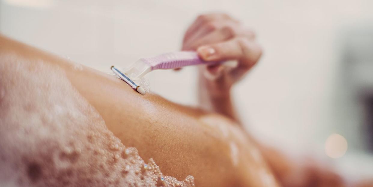 Woman shaving her legs.