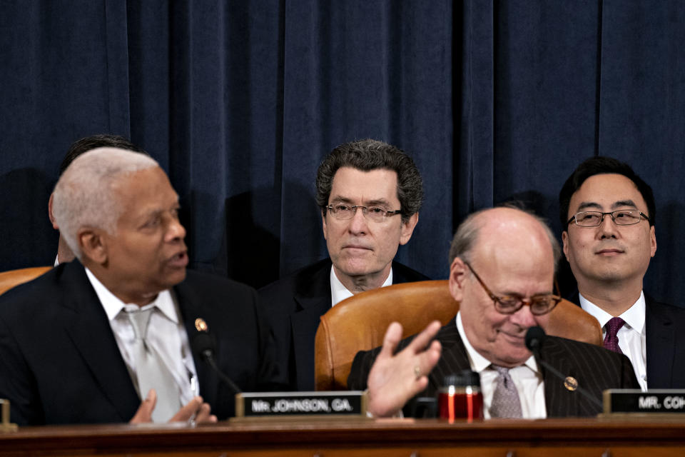 Norm Eisen sits just behind lawmakers seated at a dais.