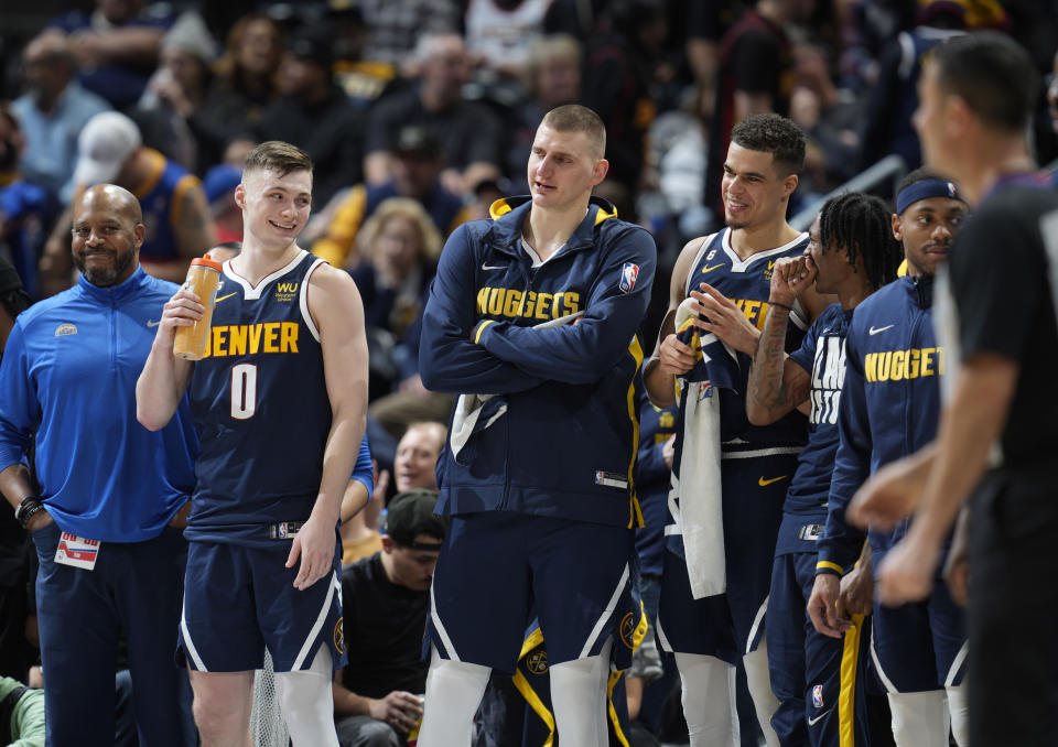 From left, Denver Nuggets guard Christian Braun, center Nikola Jokic, forward Michael Porter Jr. and guard Bones Hyland joke with each other as time runs out in the second half of an NBA basketball game against the Atlanta Hawks Saturday, Feb. 4, 2023, in Denver. (AP Photo/David Zalubowski)