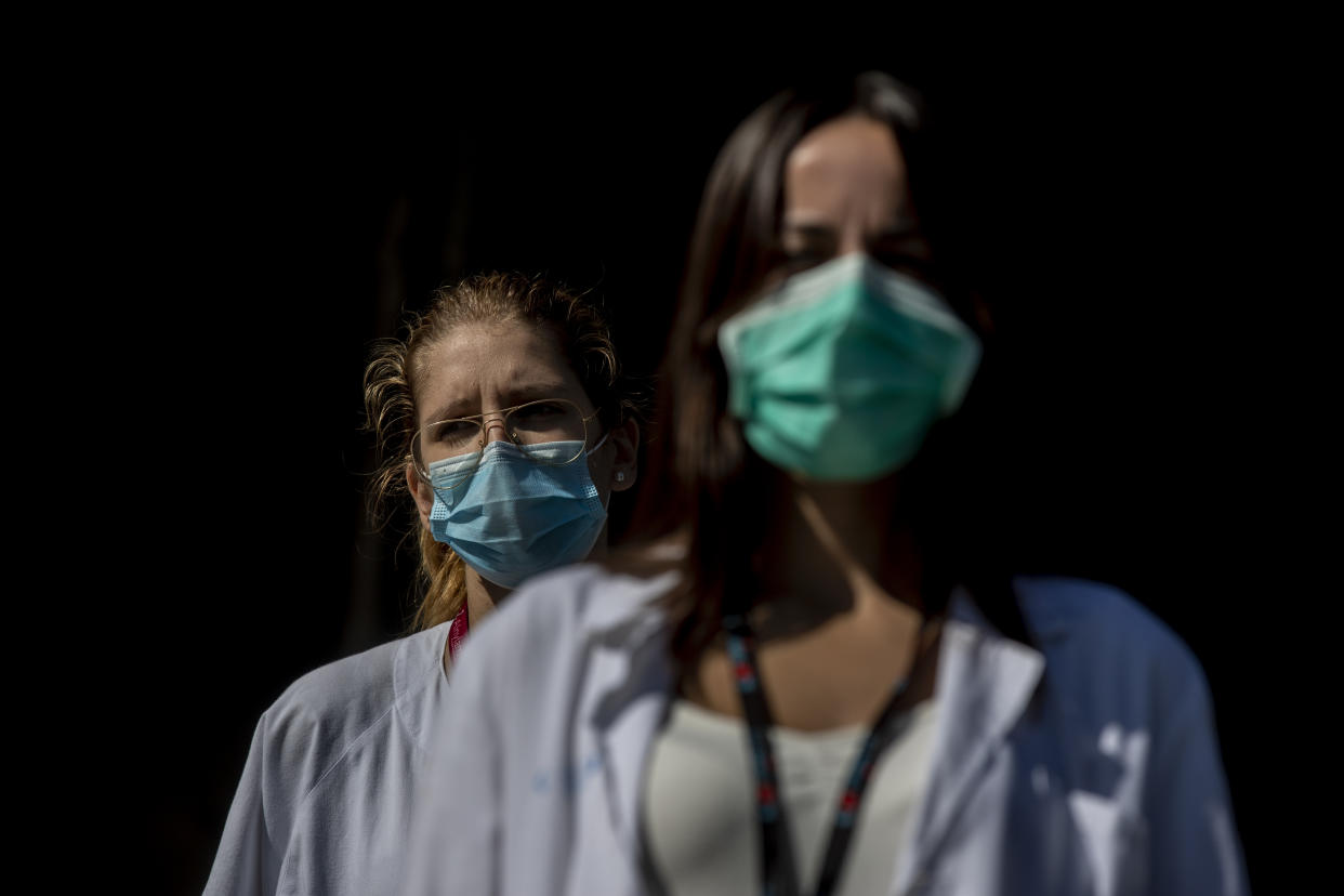 Medical staff and nurses wearing face masks to prevent the spread of coronavirus gather during a protest demanding an improvement in wages and labor conditions at the 12 Octubre hospital in Madrid, Spain, Monday, Sept. 28, 2020. Health authorities combating coronavirus in Madrid are adding a further eight areas of the Spanish capital to those with movement restrictions but have not followed a recommendation from the national government that the partial lockdown should apply to the whole city. (AP Photo/Manu Fernandez)