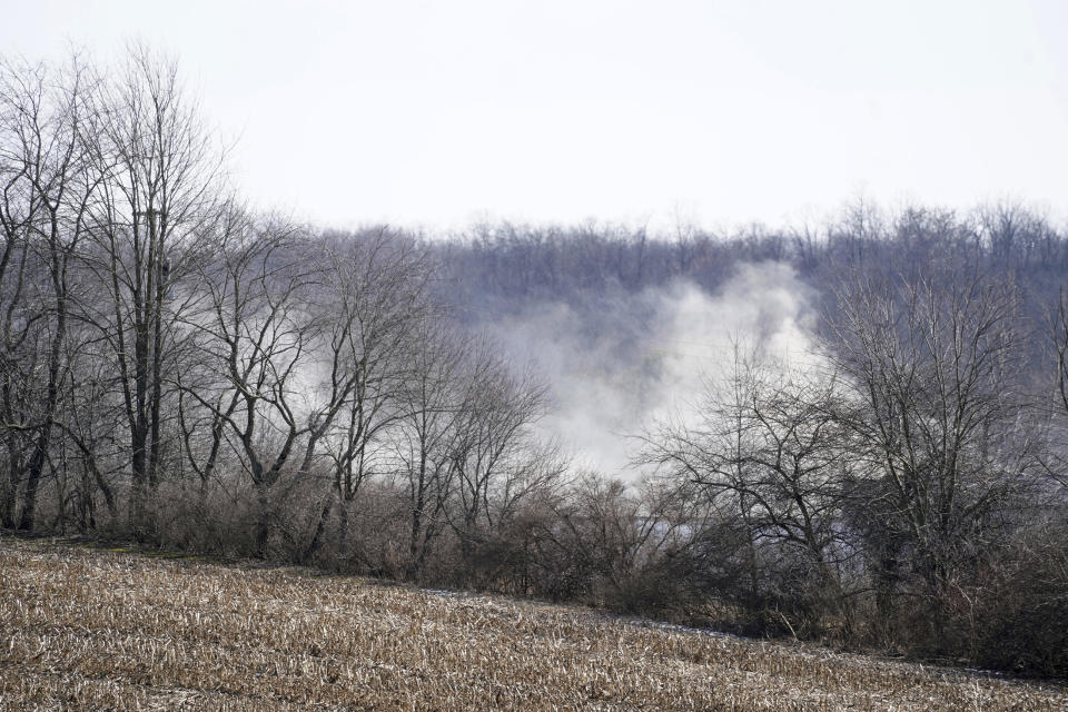 Smoke still billows from the remains of the train derailment in East Palestine, Ohio, on Sunday, Feb. 5, 2023. A smoldering tangle of dozens of derailed freight cars, some carrying hazardous materials, has kept an evacuation order in effect in Ohio near the Pennsylvania state line as environmental authorities warily watch air quality monitors. (Lucy Schaly/Pittsburgh Post-Gazette via AP)