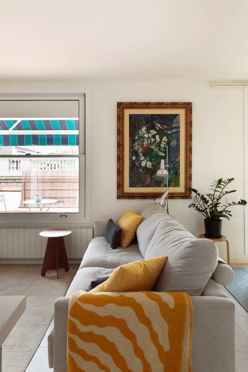 A gray couch in the living room next to a white island.