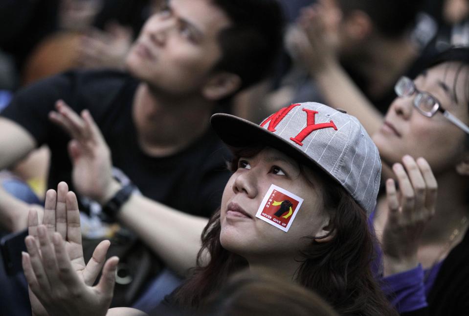 A protester displays a sticker reading "Taiwan, Never give up" during a massive protest over the controversial China Taiwan trade pact in front of the Presidential Building in Taipei, Taiwan, Sunday, March 30, 2014. Hundreds of thousands of demonstrators gathered in the streets around the parliament on Sunday to voice their opposition to a trade pact with China, part of a nearly 2-week-old protest that is challenging the president's policy of moving the democratic island economically closer to China. (AP Photo/Wally Santana)