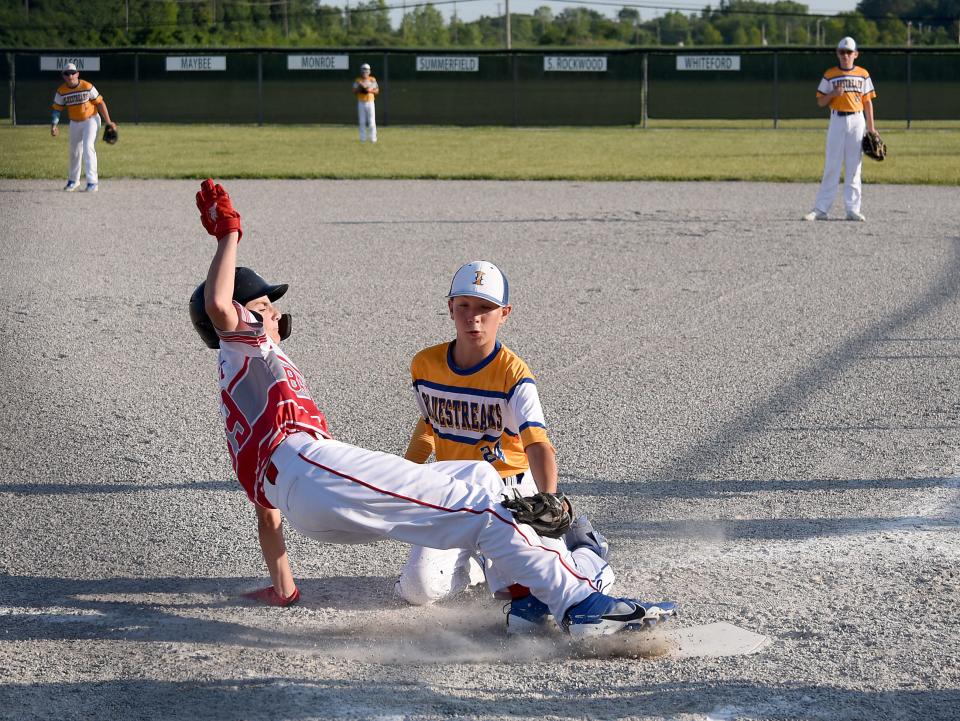 Jackson Mitchell of Bedford Elite is tagged out at the plate by Ida pitcher Parker Mason Tuesday in the 63rd Monroe County Fair Baseball Tournament. Ida won 11-1.