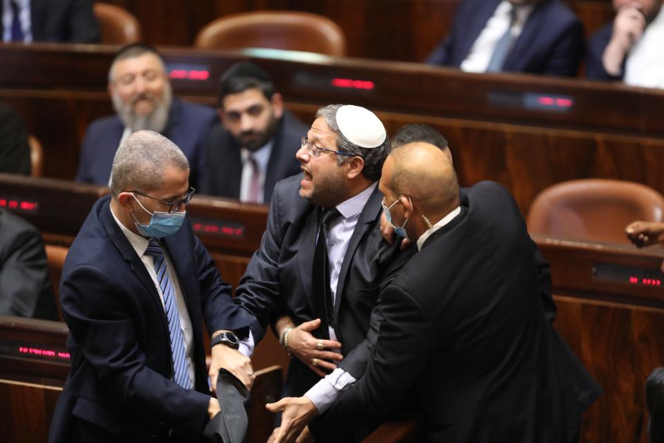 Israeli far right wing Leader of the Jewish home party, Itamar Ben Gvir escorted out by security as he protests during the speech of designated prime minister Naftali Bennett (EPA)