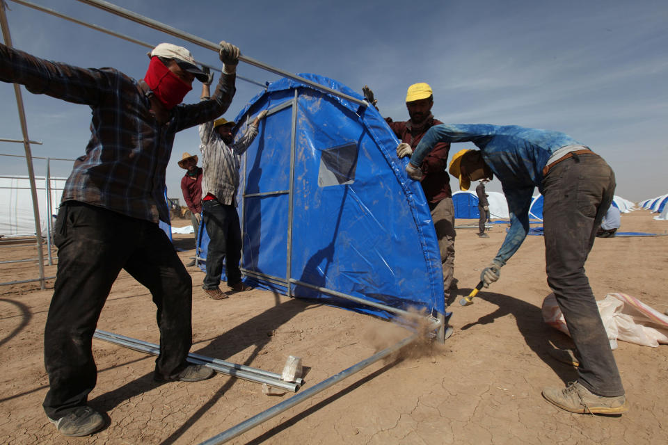 Workers prepare a tent camp in Khazer