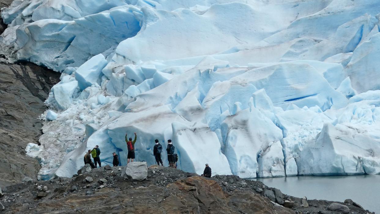 A group of people take in the views of the Mendenhall Glacier on June 8, 2023, in Juneau, Alaska. In the summer, the glacier is accessible by kayak or canoe, by foot on a challenging trail or by helicopter.