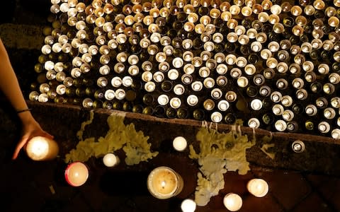 Protesters light candles in honour of a man who died after falling from a scaffolding at the Pacific Place complex while protesting - Credit: Reuters