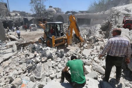 Civil defence members work at a site hit by a barrel bomb in the rebel held area of Old Aleppo, Syria July 11, 2016. REUTERS/Abdalrhman Ismail - RTSHDMU