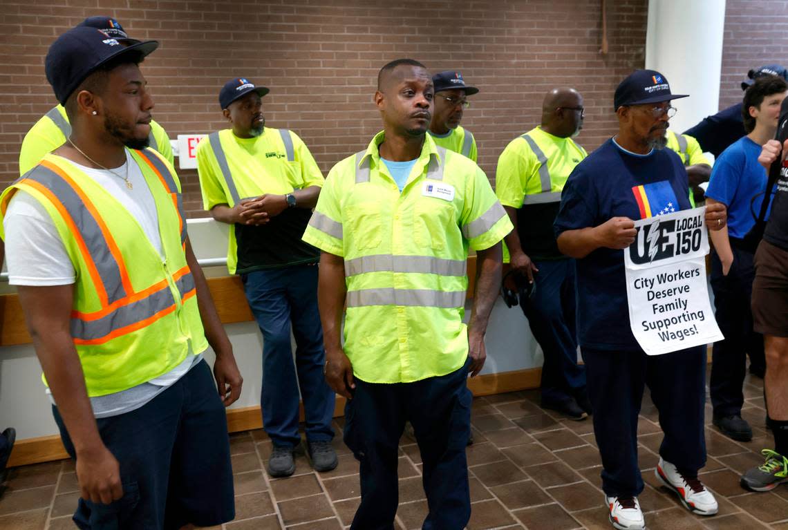Terrance Mack, center, and other sanitation workers wait to head into the Durham city council chambers to attend a council work session at City Hall in Durham, N.C., Thursday, Sept. 7, 2023.