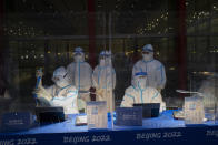 FILE - Olympic workers in protective gear work at a credential validation desk at the Beijing Capital International Airport ahead of the 2022 Winter Olympics in Beijing, Jan. 24, 2022. (AP Photo/Jae C. Hong, File)