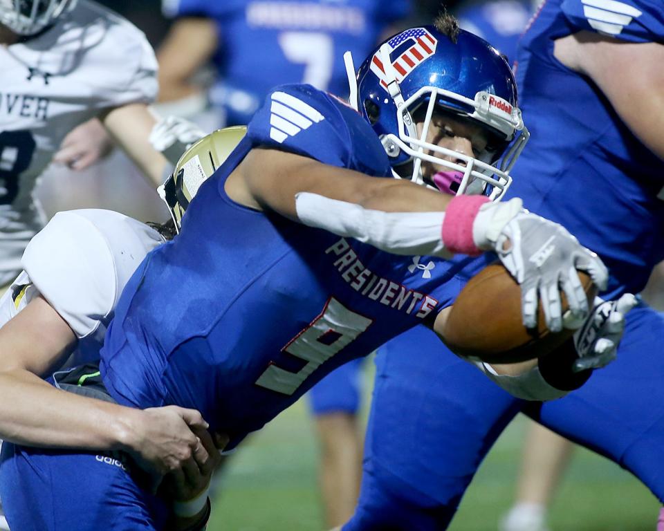 Quincy's Gabriel Rodrigues extends the football to break the plane for the touchdown to cut Hanover’s lead to 7-6 during first quarter action of their game against Hanover at Veterans Memorial Stadium in Quincy on Friday, Oct. 7, 2022.