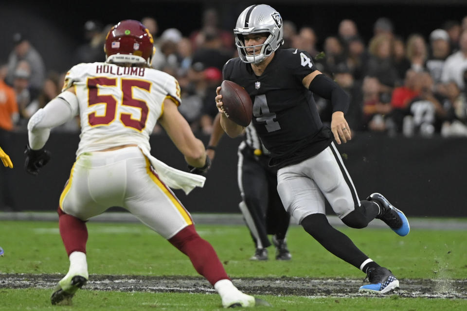 Las Vegas Raiders quarterback Derek Carr (4) runs against Washington Football Team outside linebacker Cole Holcomb (55) during the first half of an NFL football game, Sunday, Dec. 5, 2021, in Las Vegas. (AP Photo/David Becker)