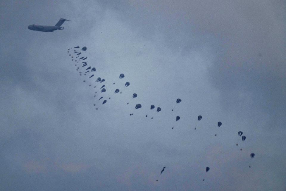 An aircraft airdrops humanitarian aid over Gaza the northern Gaza Strip, as seen from southern Israel, Friday, March 8, 2024. (AP Photo/Leo Correa)