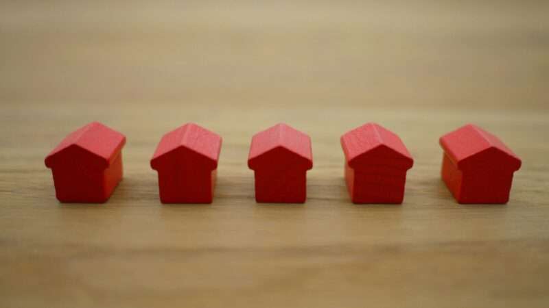 A little row of red wooden houses sits on a table