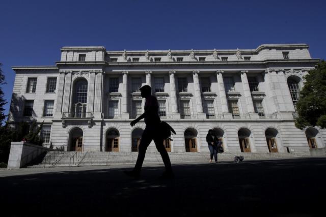 People walk in front of Wheeler Hall on the University of California campus in Berkeley, Calif., Wednesday, March 11, 2020. UC Berkeley has suspended in-person classes due to coronavirus concerns. (AP Photo/Jeff Chiu)