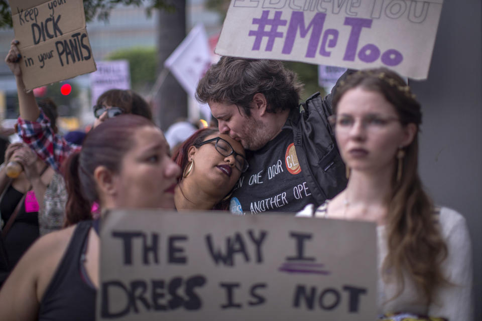 Protesters hold up signs denouncing sexual misconduct.